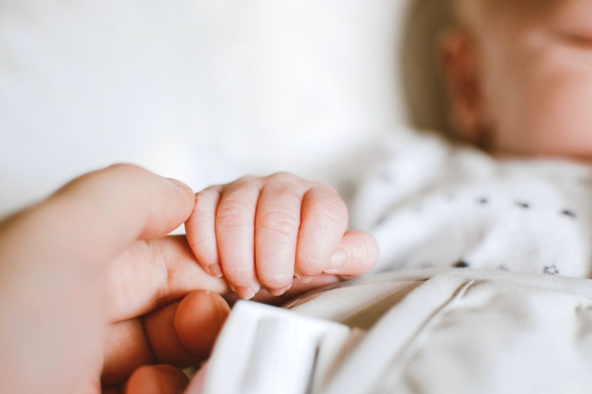 baby clasping mom's finger